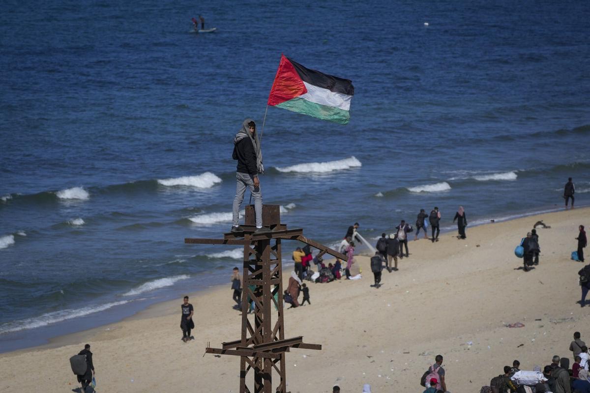 27 de enero de 2025, Gaza.- Un joven levanta una bandera de Palestina en una playa de Gaza